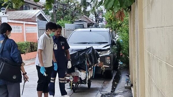 Бездомный мужчина задыхается под пластиковой простыней под дождем в Нонта-Бури