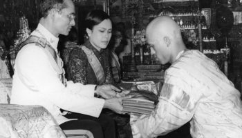 Тысячи людей аплодируют, когда принц надевает шафрановое одеяние