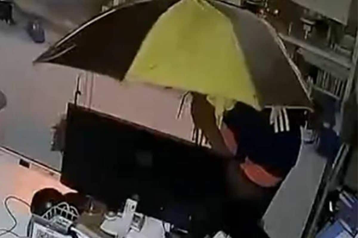 Вор с зонтиком карабкается по потолку, чтобы украсть, но получает всего 100 бат