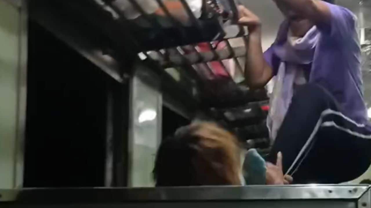 Тайская женщина пытается столкнуть попутчика с движущегося поезда