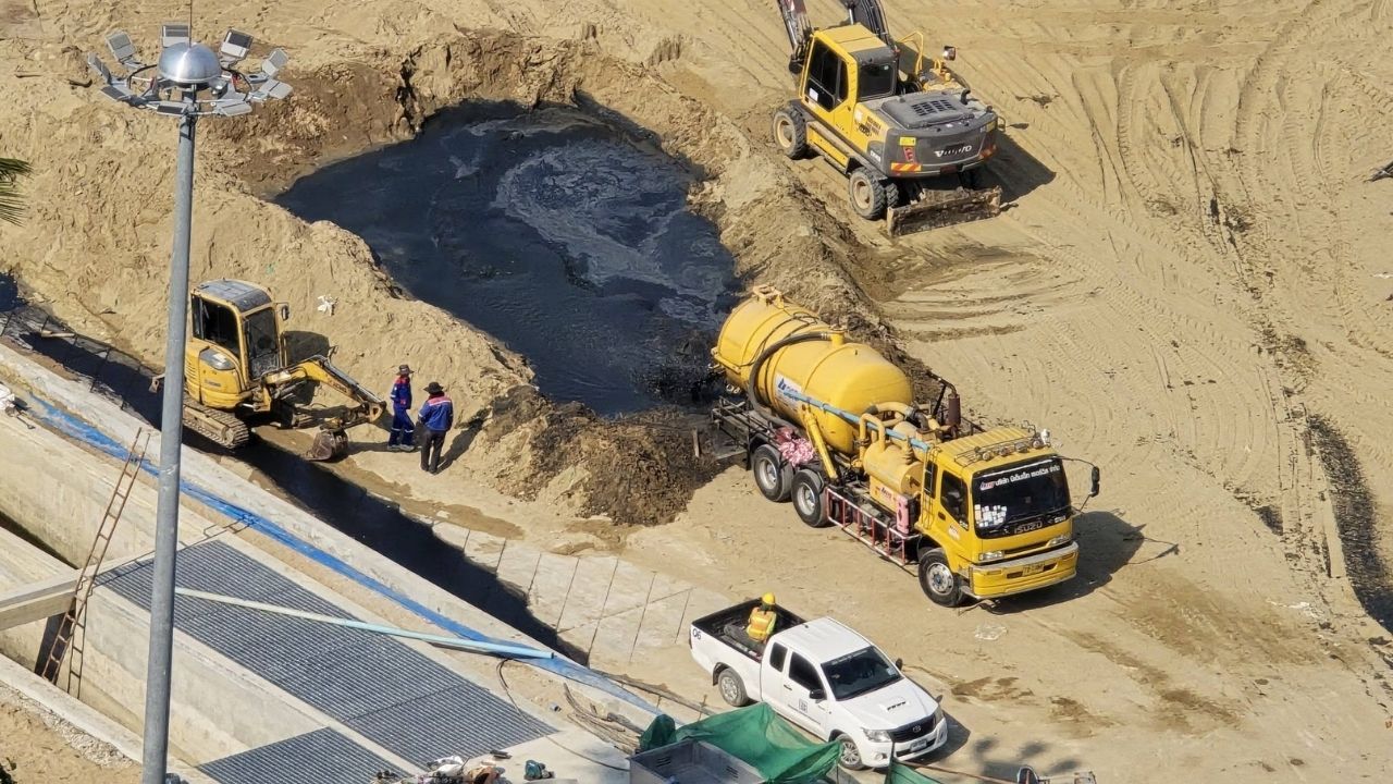 Иностранный мужчина поднимает флаг загрязнения моря на пляже Джомтин в Паттайе