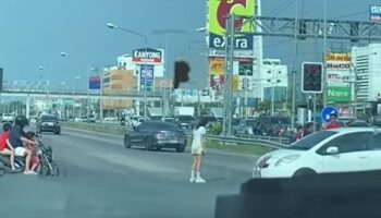 Женщина из Чонбури сидит на дороге и бросает обувь после ссоры с бойфрендом