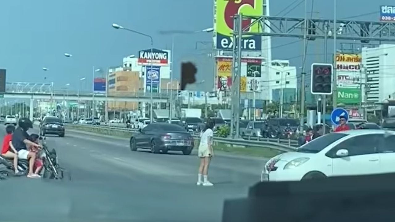 Женщина из Чонбури сидит на дороге и бросает обувь после ссоры с бойфрендом